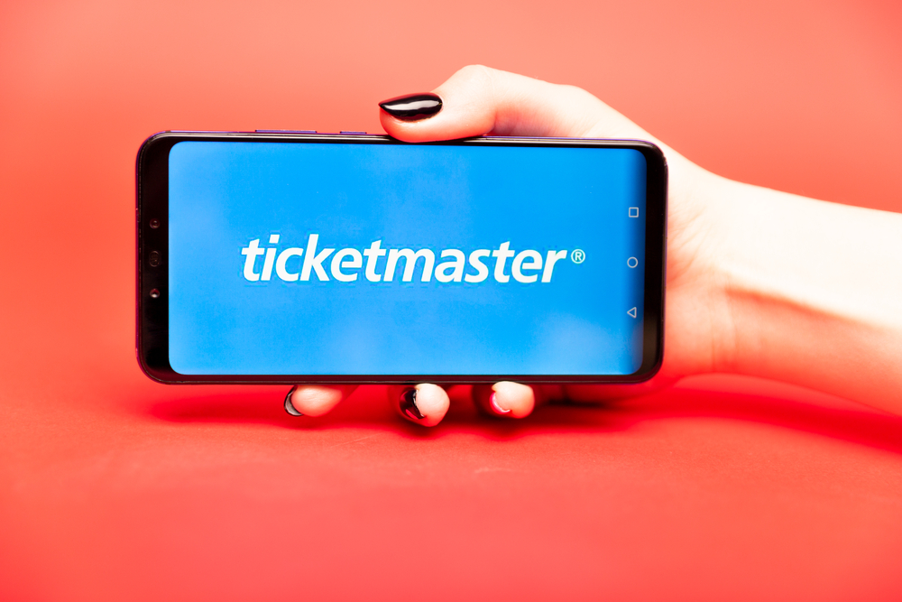 woman holding a phone with ticketmaster on the screen
